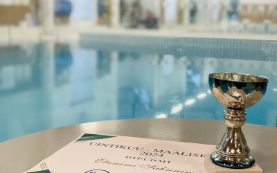 taustalla uima-altaat pöydällä diplomi sekä hopeinen pokaali