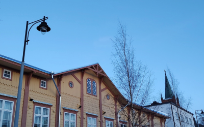 Seikowin päiväkodin päärakennuksen yläosa ja katulamppu kuvassa. Taustalla näkyy Uudenkaupungin Uuden kirkon torni.